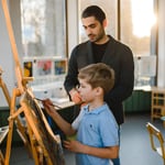 Educator supporting a child during a creative activity