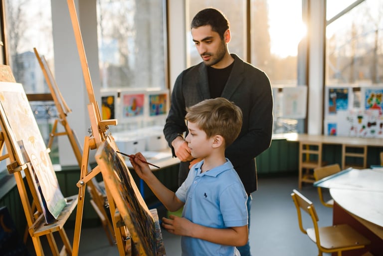 Educator supporting a child during a creative activity